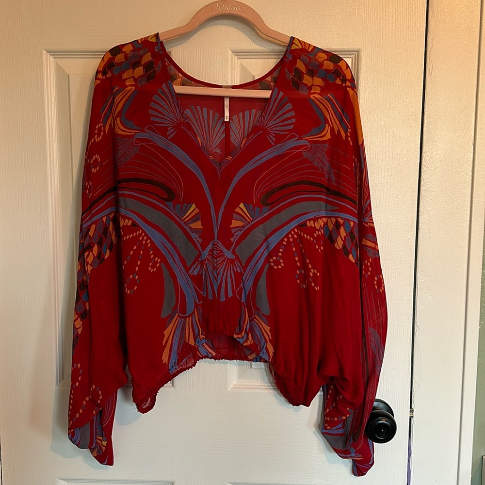 Free People sheer, vibrant v-neck blouse.